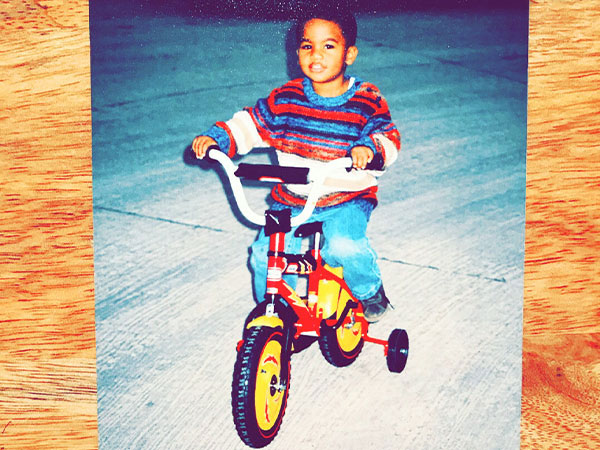Young Caz on little red bike with training wheels