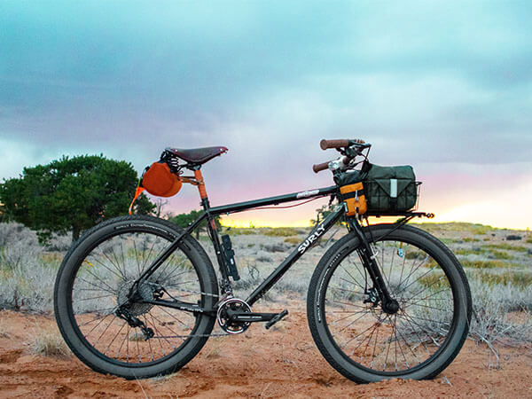 Bridge Club bike side view out in desert, front rack and bag, saddle bag