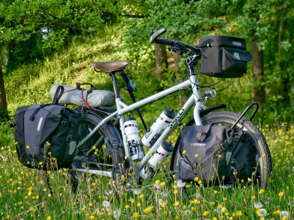 Troll bike fully loaded with pannier bags, handlebar bag, and three large waterbottles