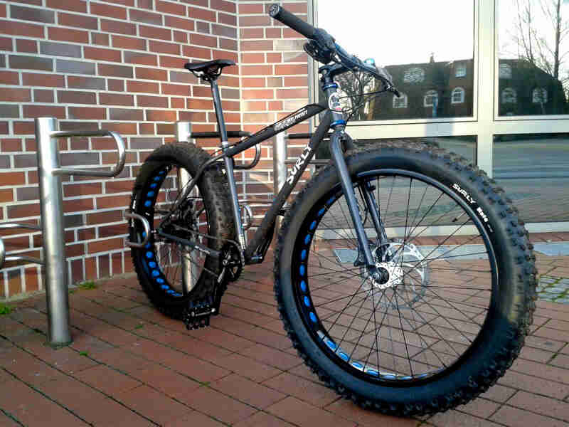 Surly Pugsley fat bike - gray - right side view - parked on red bricks in front of a brick wall and windows