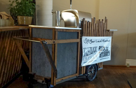 A wood and steel beer service cart with taps, parked in a room