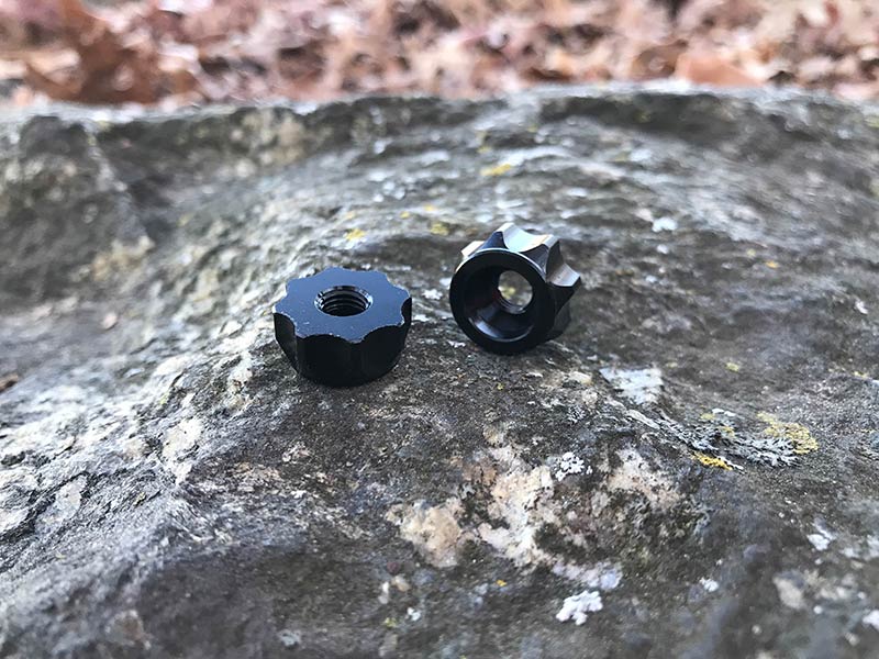 A pair of Problem Solvers Super P-Nuts for a tubeless rim valve stem, on top of a rock