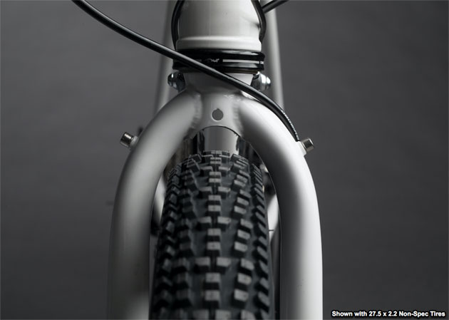 Zoomed in front view of the headset, fork and knobby tire of a Surly Midnight Special bike with gray background