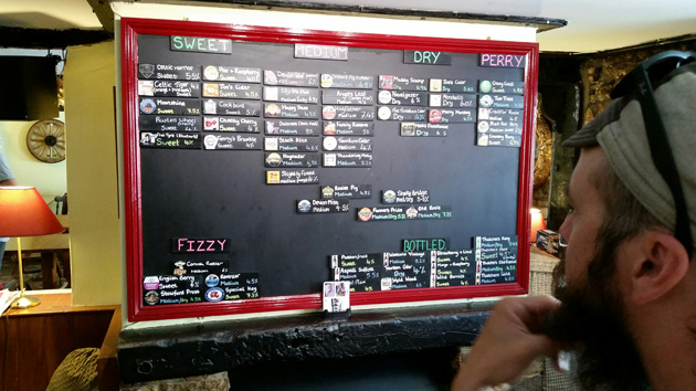 Person looking at a beer menu board with a red frame at an ordering counter