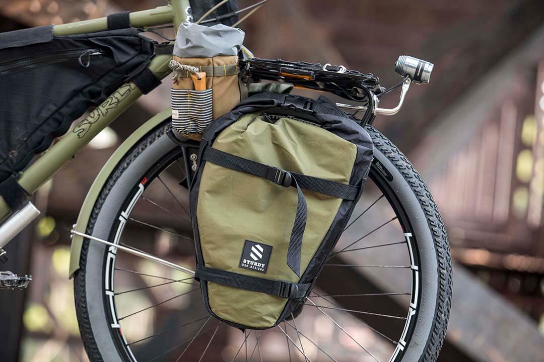 Right side, front end view of an olive drab Surly Bridge Club bike, with saddle bag and headlight