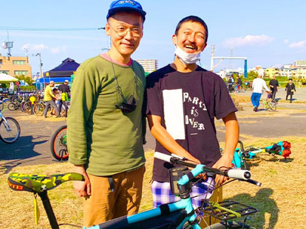 Kaneyan smiling posing for photo with friend at bike event