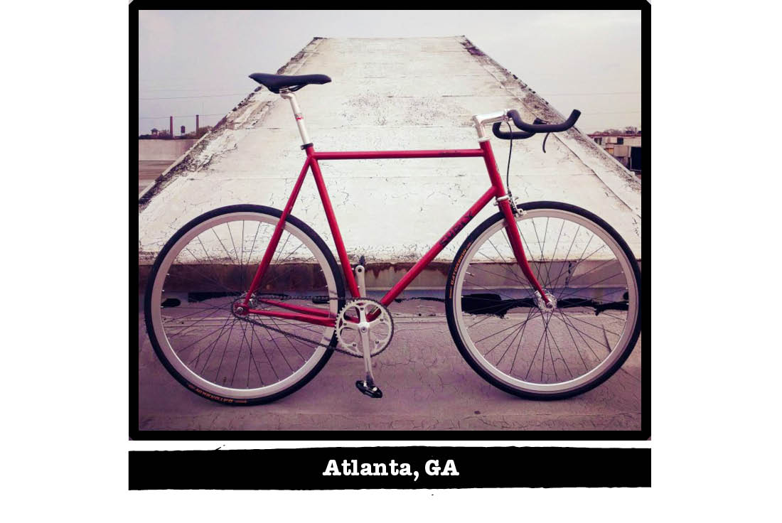 Right profile of a red Surly bike on a rooftop with a pyramid shaped vent in background - Atlanta, GA tag below image