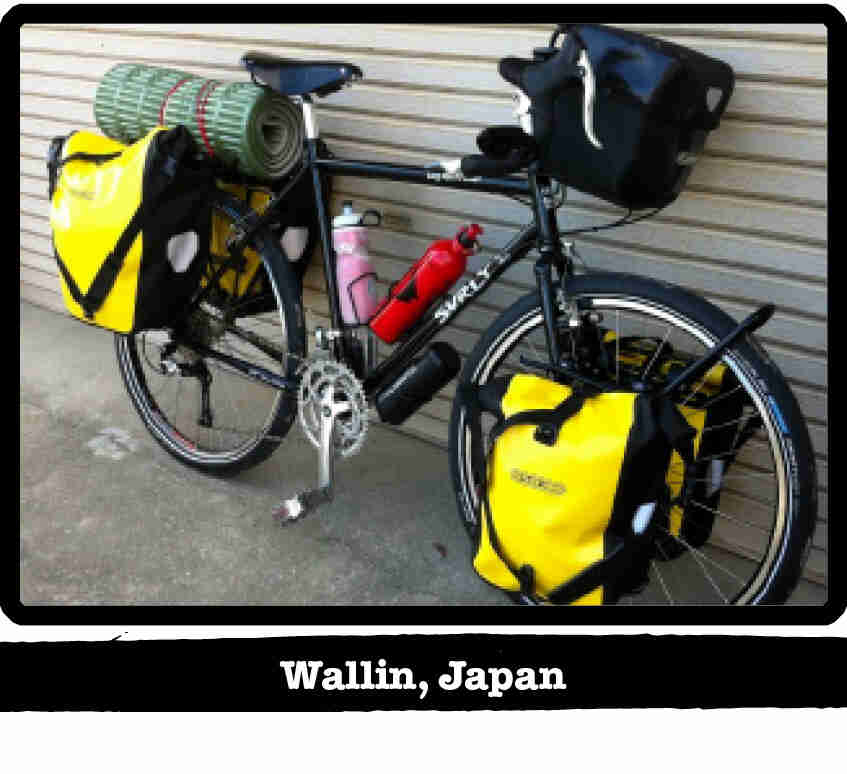 Front right side view of a Surly bike, loaded with gear, leaning against a wall - Wallin, Japan tag below image