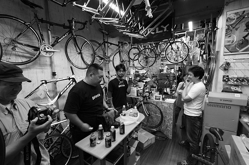 People standing around in a bike shop - black & white image