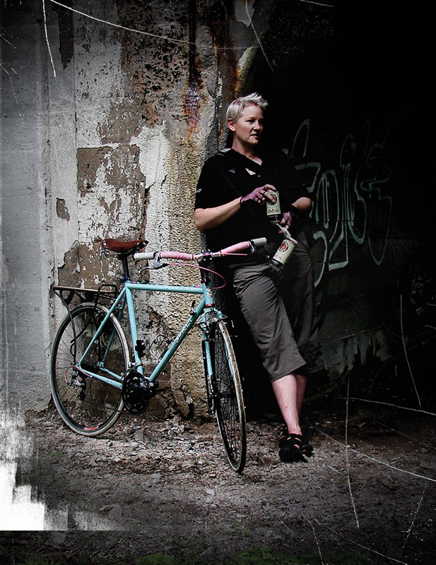 Right side view of a mint Surly bike, parked in front of a person holding beer cans and standing against a cement wall