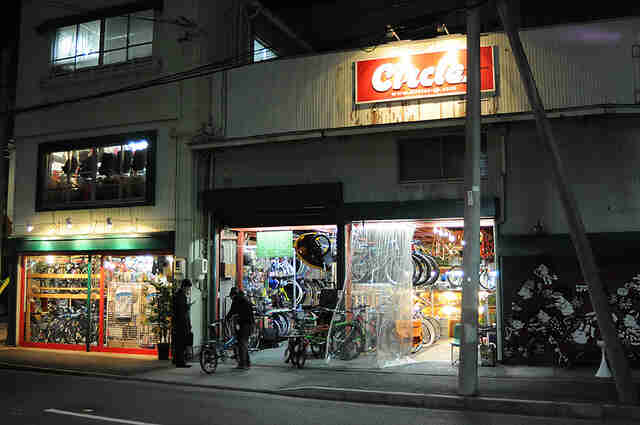 Street view of the storefront of Circles bike shop building, at night