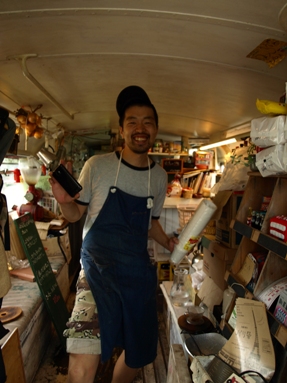 Front view of a person working in a double decker bus that was converted into a diner and cafe