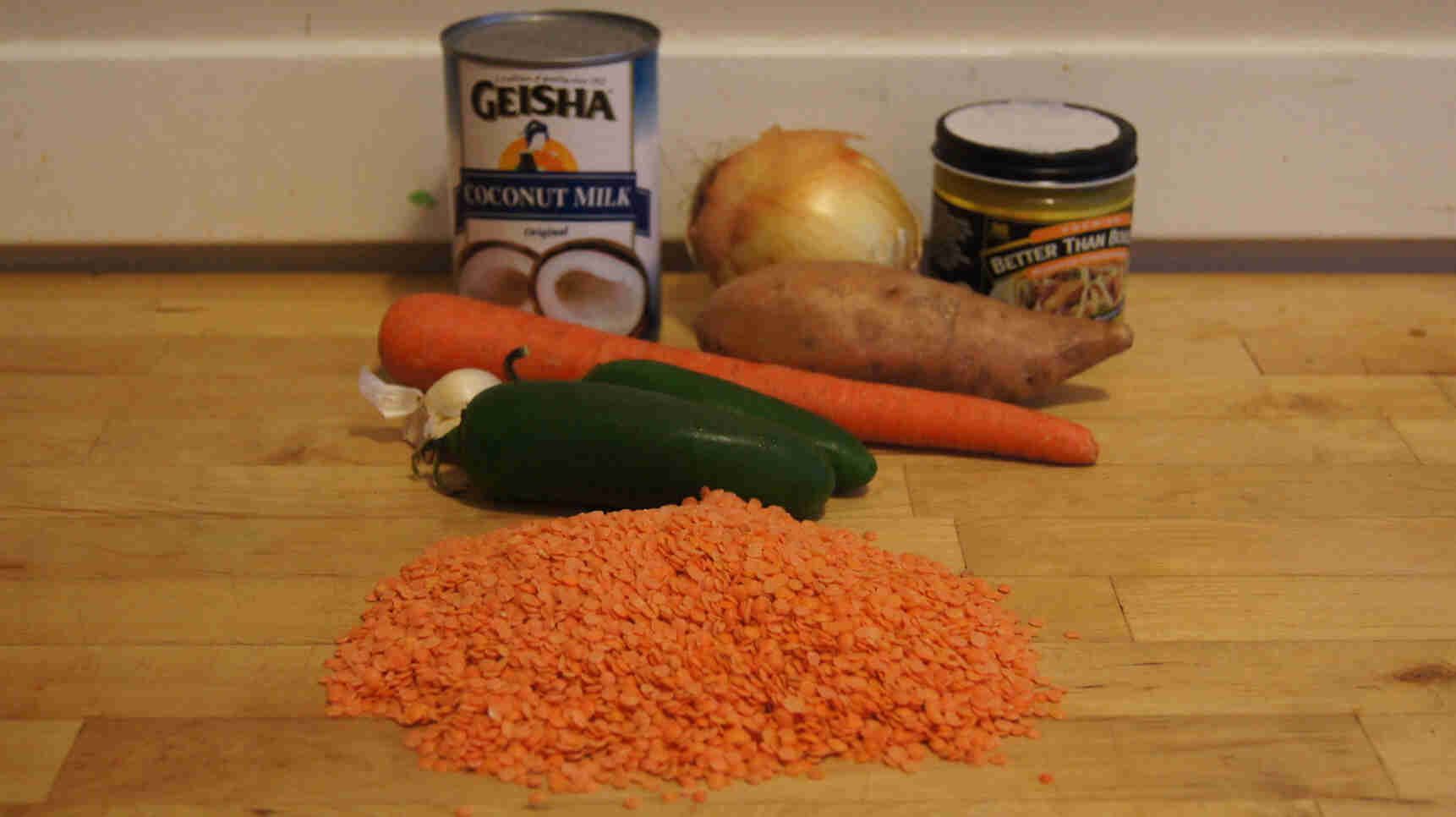 Front view of soup ingredients on top of a wood countertop