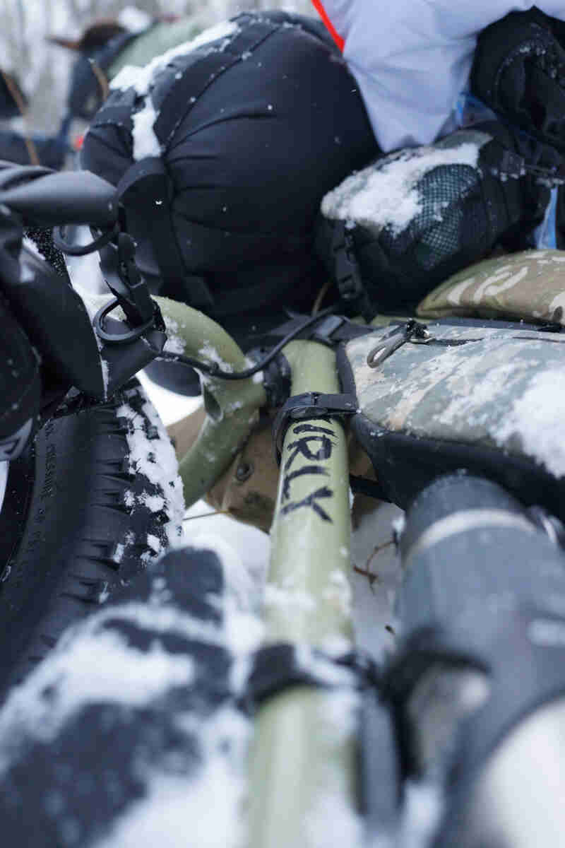 Zoomed in view of a Surly fat bike, loaded with gear, laying in the snow