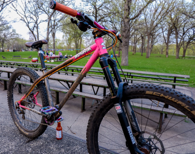 Surly Instigator bike - pink and gray - right side view - city park setting with picnic table in the background