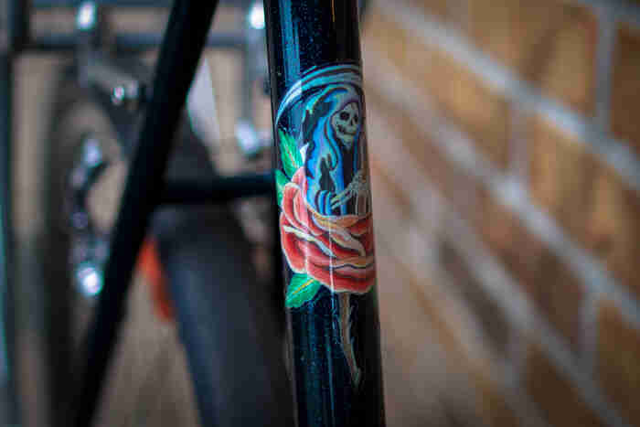 Surly Travelers Check bike - green - seat tube with a skeleton & rose sticker detail - front view