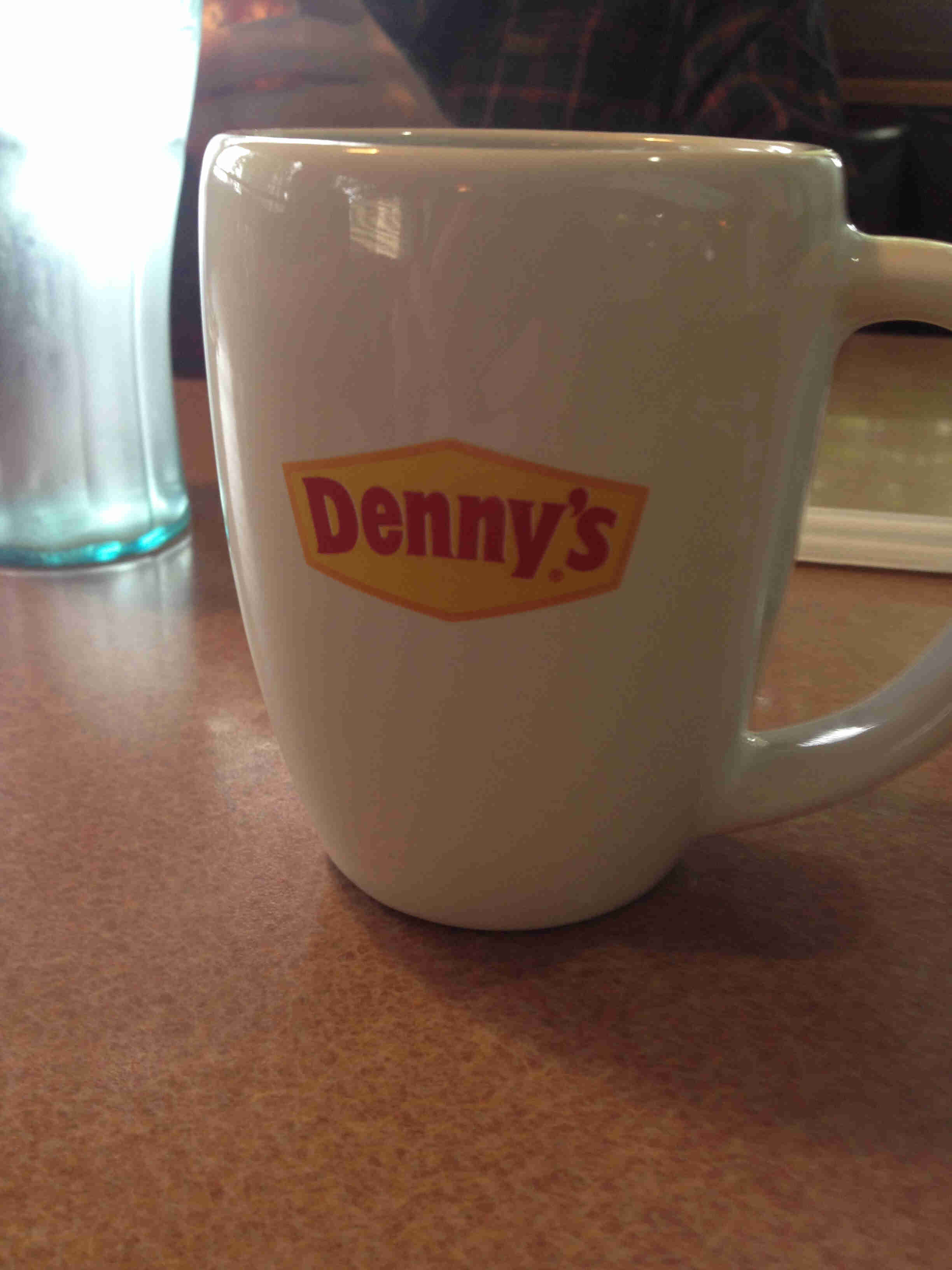 Close up, front view of a Denny's restaurant coffee cup sitting on a table
