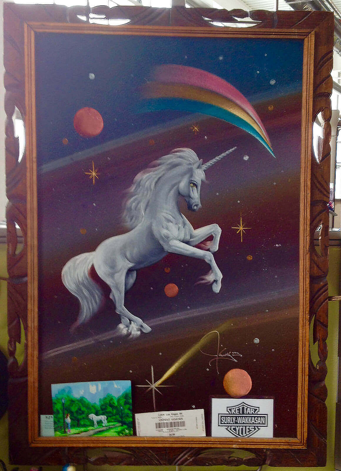 Framed, colored illustration of a unicorn, with planets, stars and a rainbow