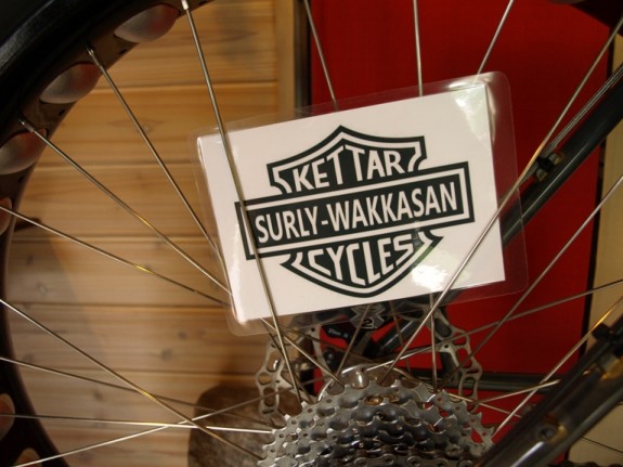 Right side, inner view of a Surly fat bike wheel, with a black & white, laminated card, displayed in the spokes