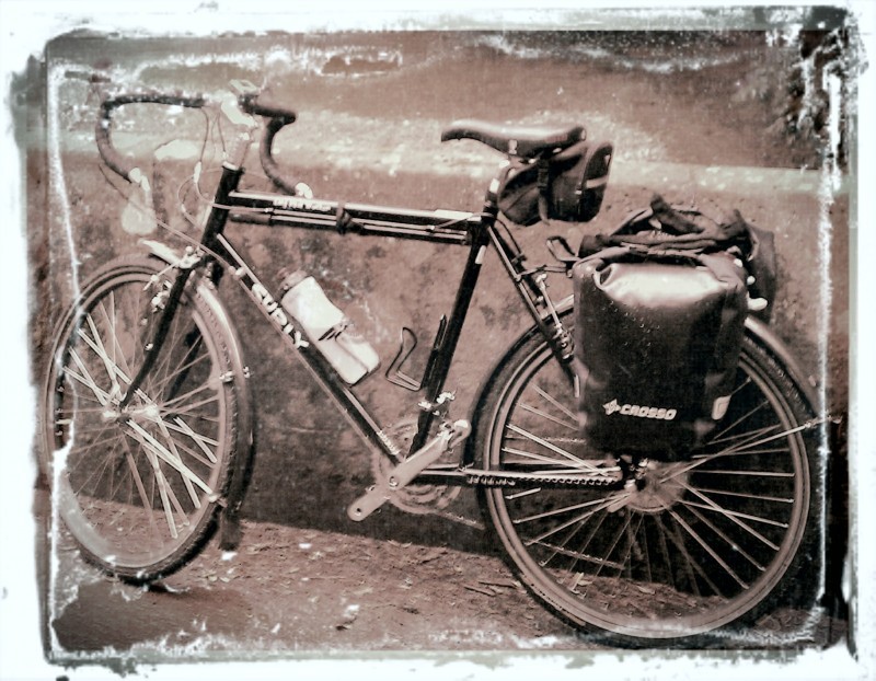 Left side view of a Surly Long Haul Trucker bike with rear saddlebags, leaning on a wall - black & white rendering