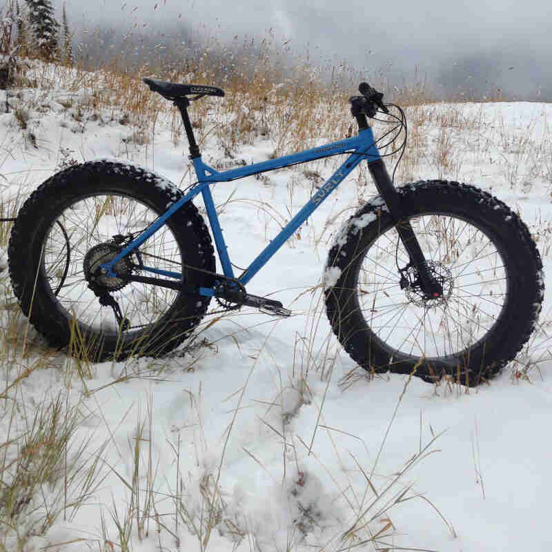 Right profile of a Surly fat bike, blue, standing in a snowy field