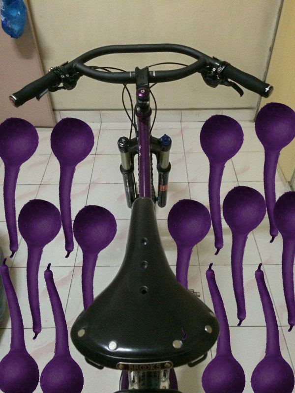 Downward view of a Surly bike, purple, parked on a tile floor in a room - gourd graphics surrounding the bike