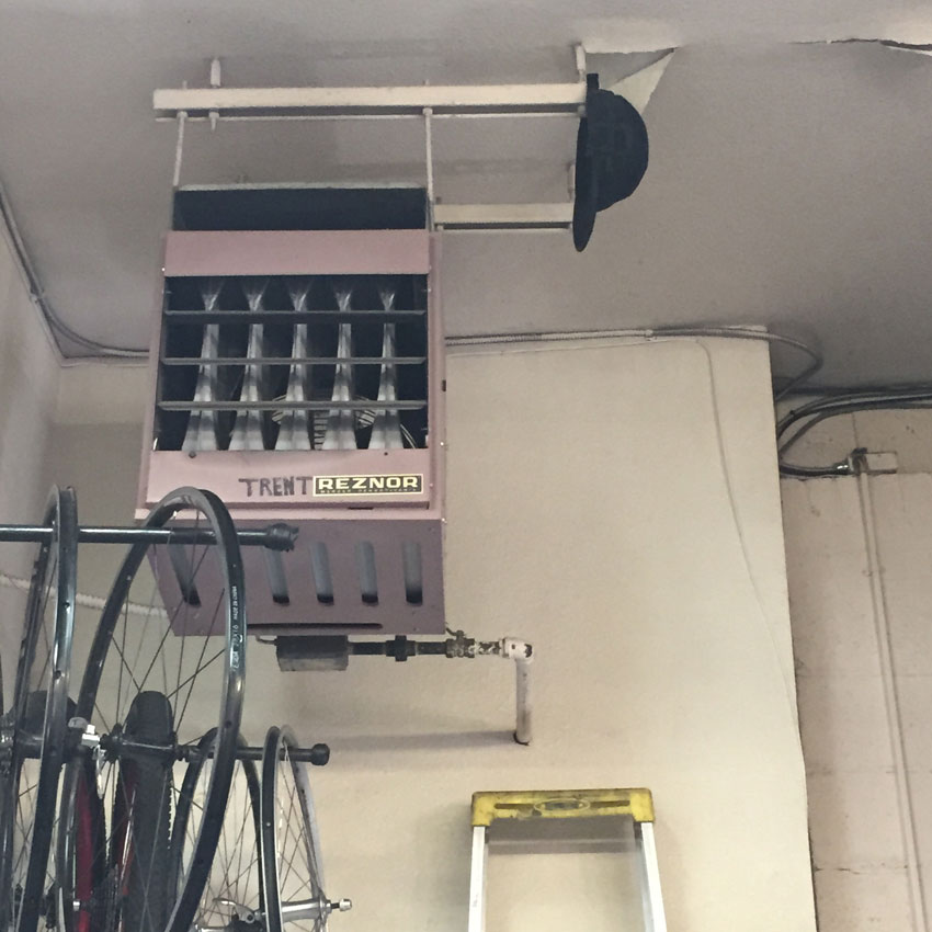 A ceiling mounted heater, hanging over bike rims