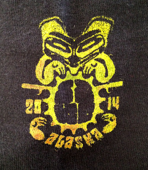 A yellow graphic on dark fabric, with text showing, 2014 Alaska