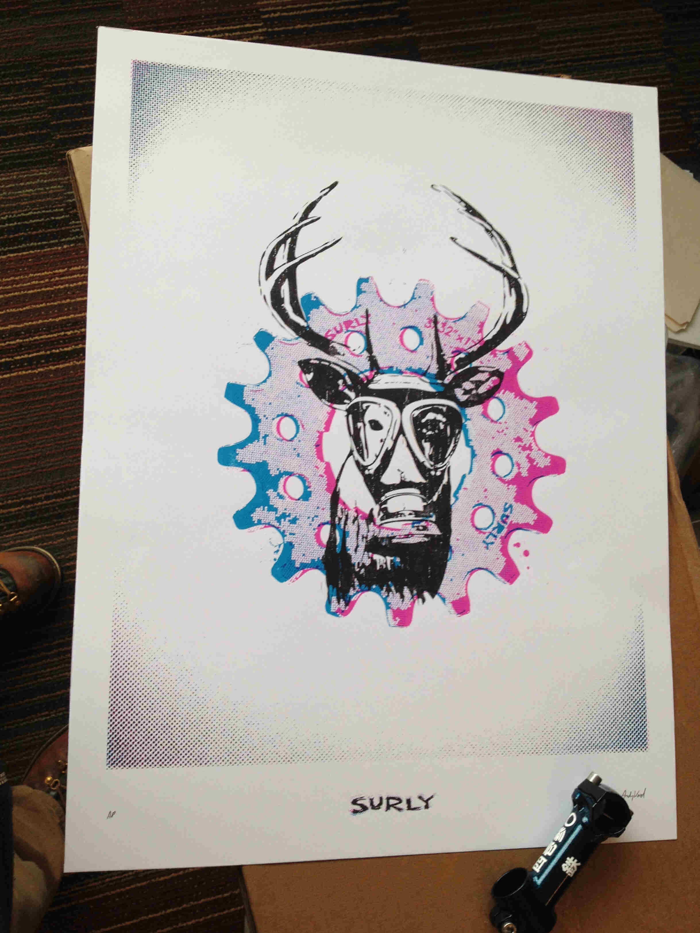 White paper with a colored graphic illustration of a deer with a gas mask, a bike gear, and a Surly Bikes logo on bottom