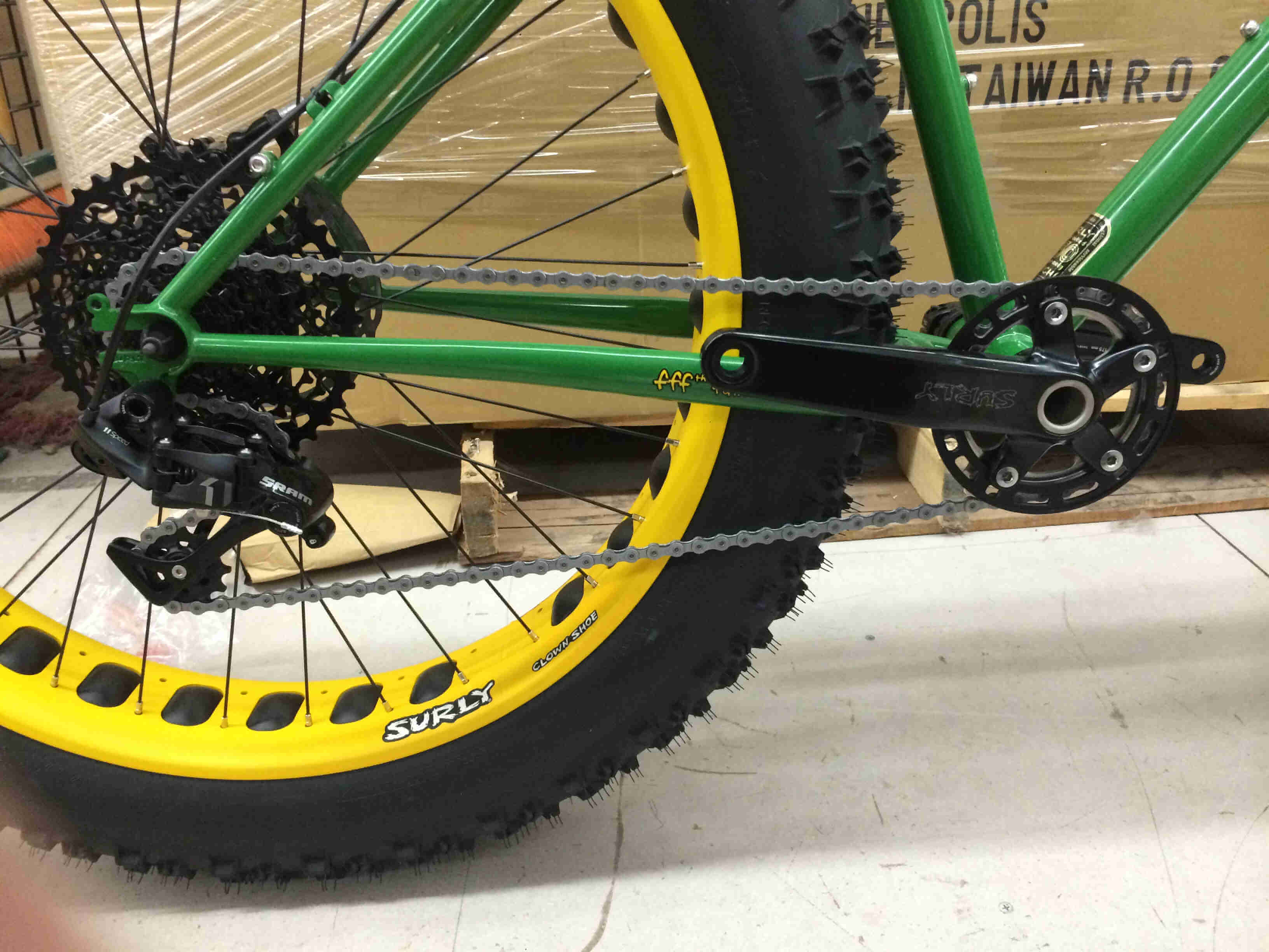 Close up, right side view of the drive train on a green Surly Moonlander bike
