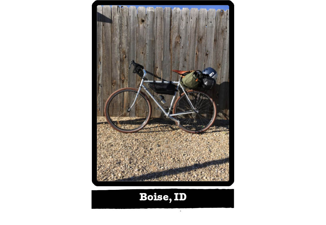Right side view of a Surly bike, loaded with gear, against a wood fence - Boise, ID tag below image