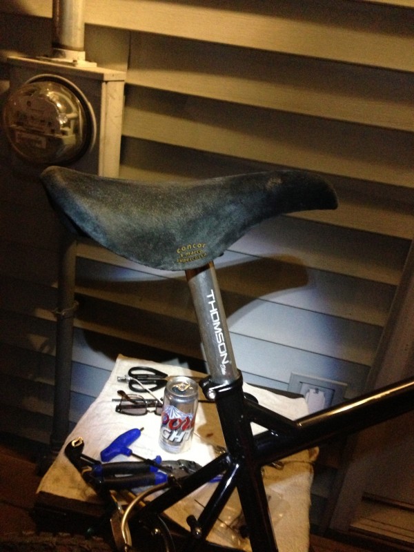 Right side view of a San Marco bike saddle mounted to a Thomson seatpost, on a Surly Troll bike, that's next to a wall