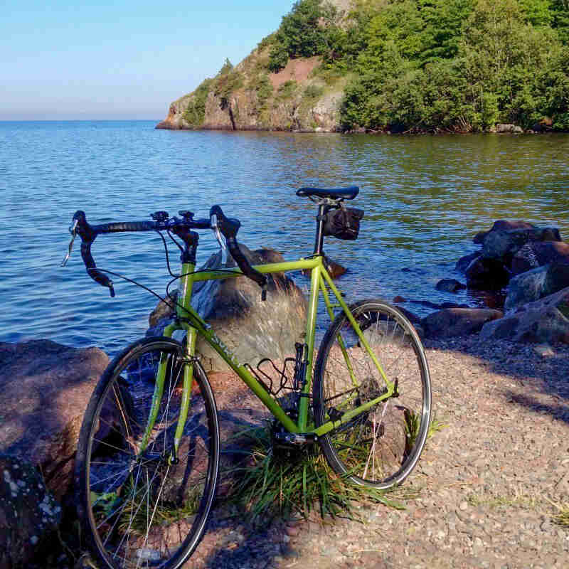 Front left side view of a green Surly bike on the bank of a North Shore bay