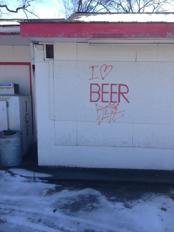 An exterior wall of a white building, with, I love beer, written on it