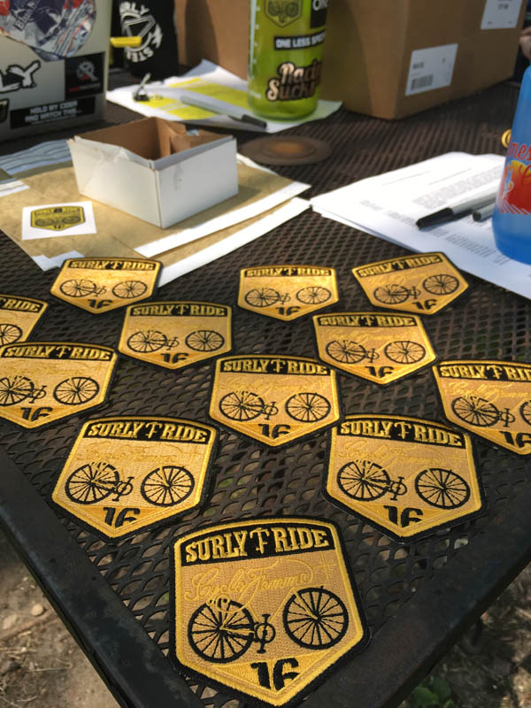 Surly CycloFemme patches laying on a table - black and gold colored 