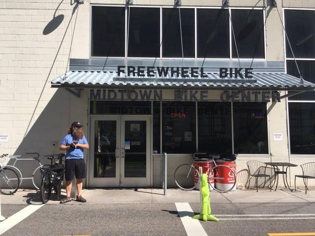 A person standing in front of the Freewheel Bike Shop building
