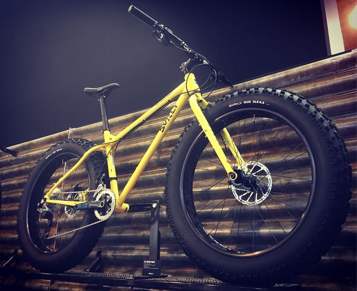 Right side view of a Surly Ice Cream Truck bike, yellow, in front of a steel wall