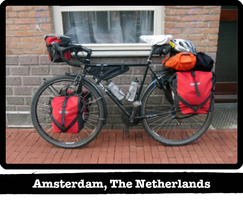 Left side view of a Surly bike loaded with gear, on a red brick sidewalk - Amsterdam, The Netherland tag below image