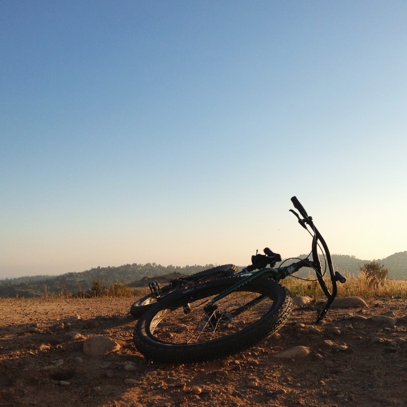 Front, ground level view of a Surly Krampus bike, laying on it's left side in a rocky field, with hills in background