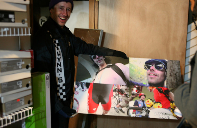 A person holding a photo collage while standing in an office doorway 