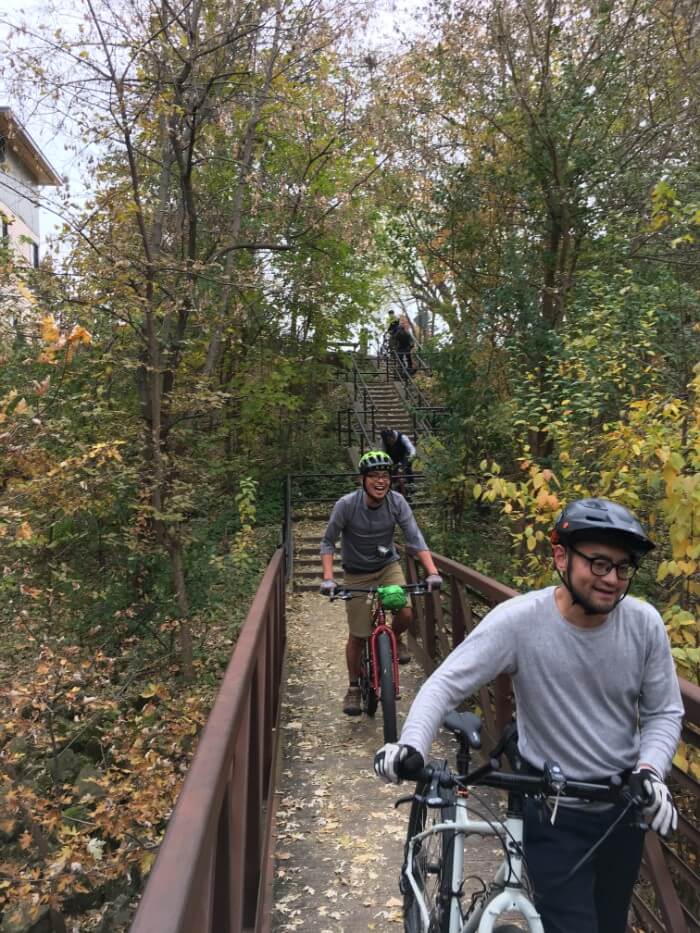 Cyclists cross a bridge over a creek