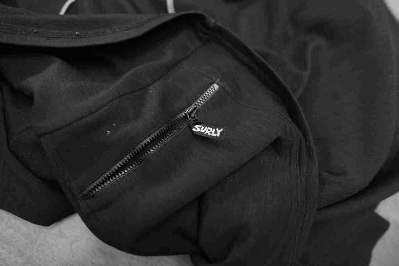 Downward view of the zipper pocket detail from a Surly Bikes long sleeve biking jersey