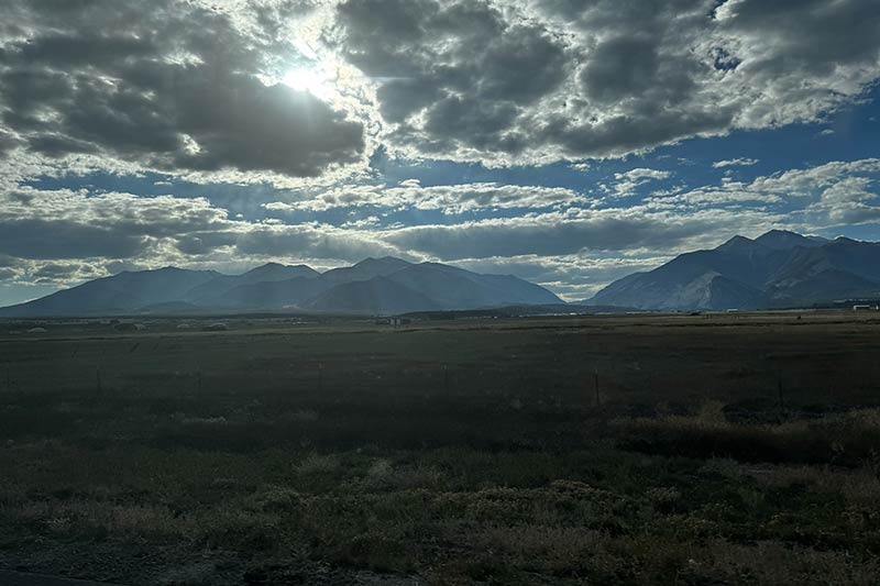 Sun peaking through clouds in valley