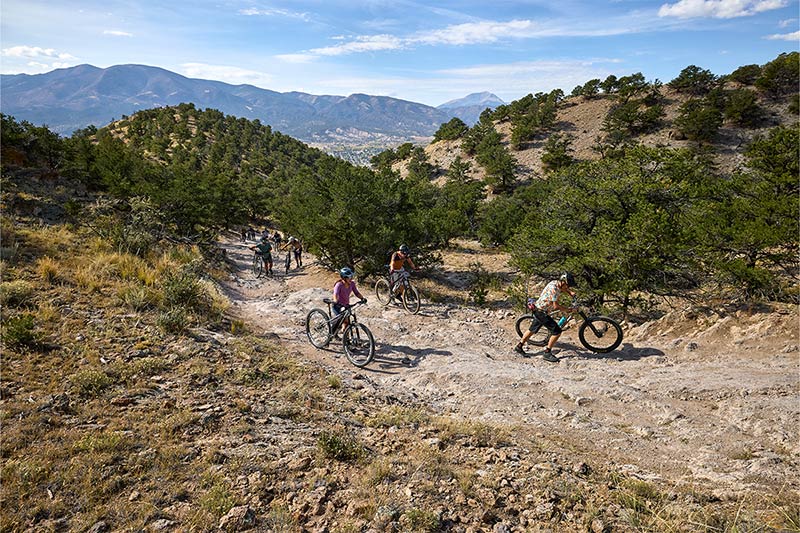 Single speeders walking up steep rocky climb