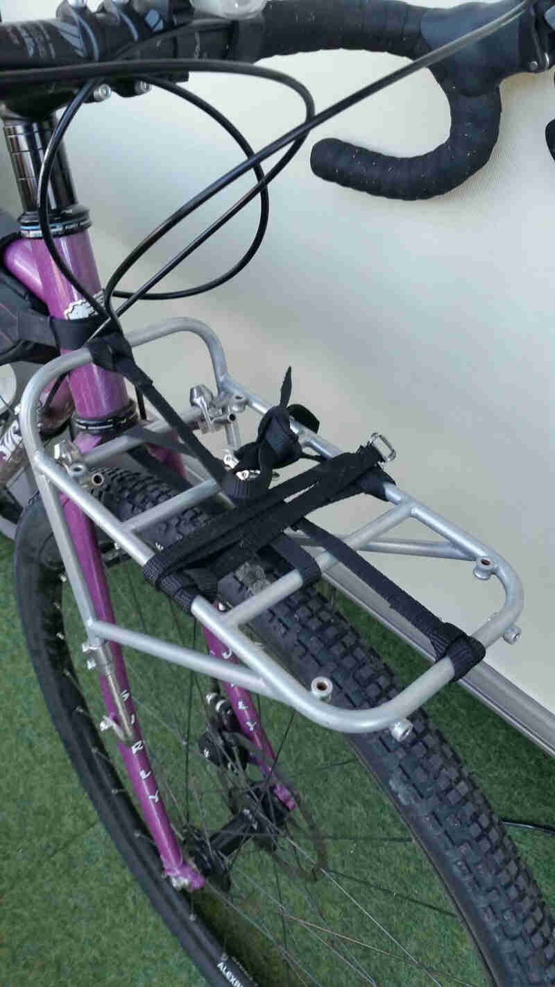 A Surly Junk strap - black - wrapped around a front rack on a Surly bike