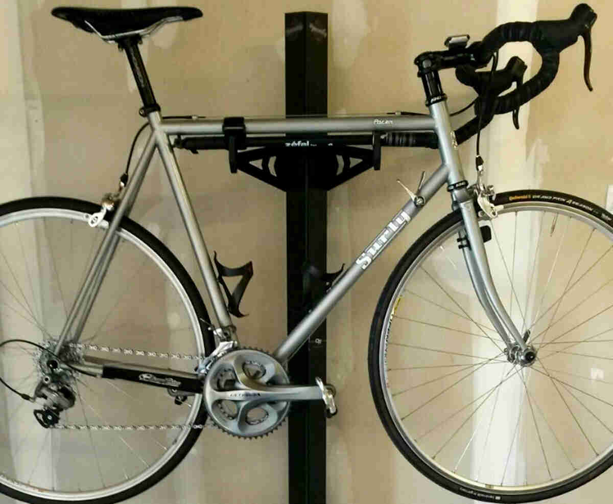 Right side view of a silver Surly Pacer bike, on a bike mount against a wall