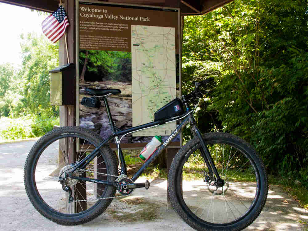 Right side view of a Surly Krampus bike, parked in front of a Cuyahoga Valley National Park sign
