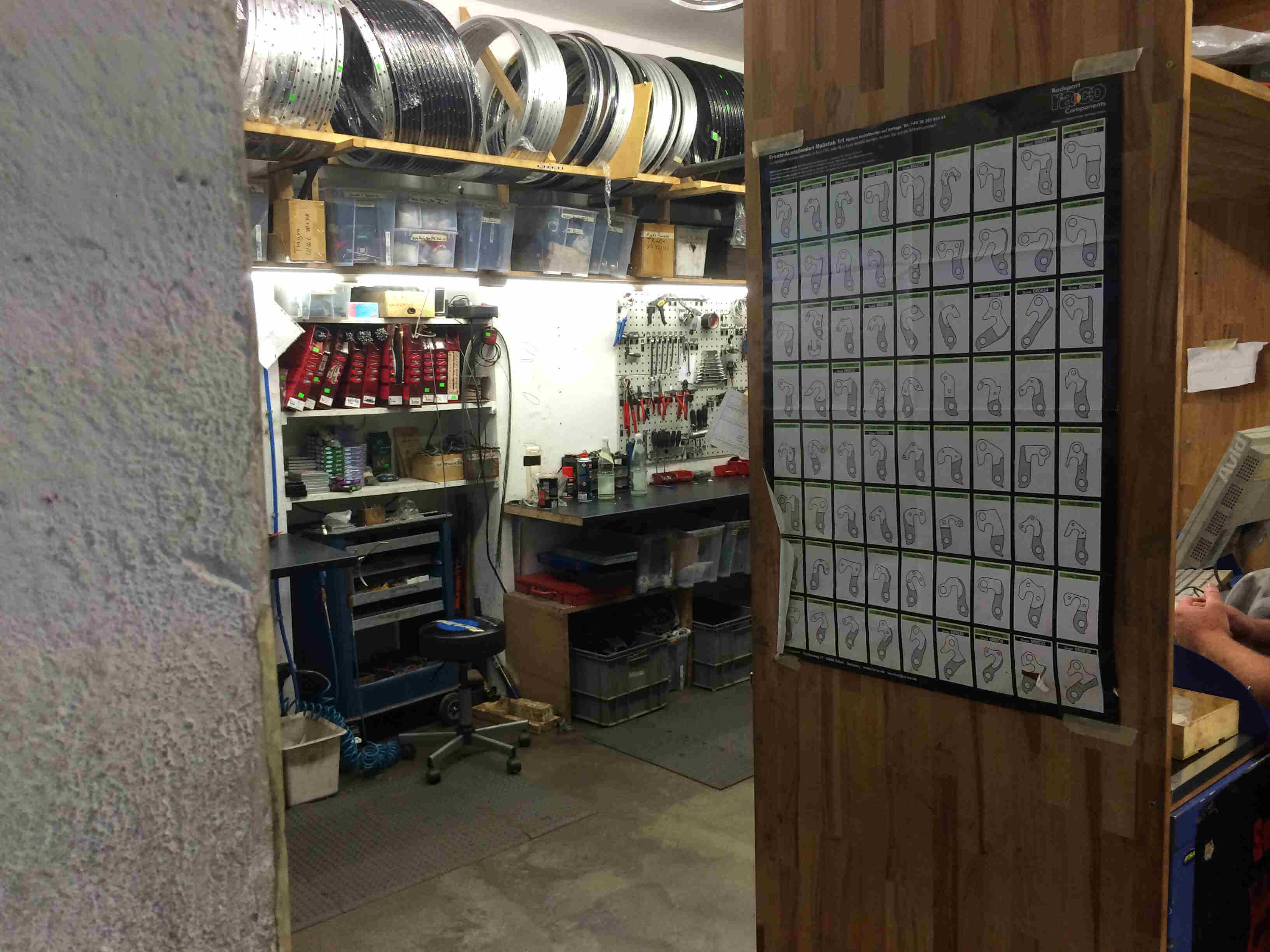 A back room workshop in a bike shop, with rims lined up on a high shelf