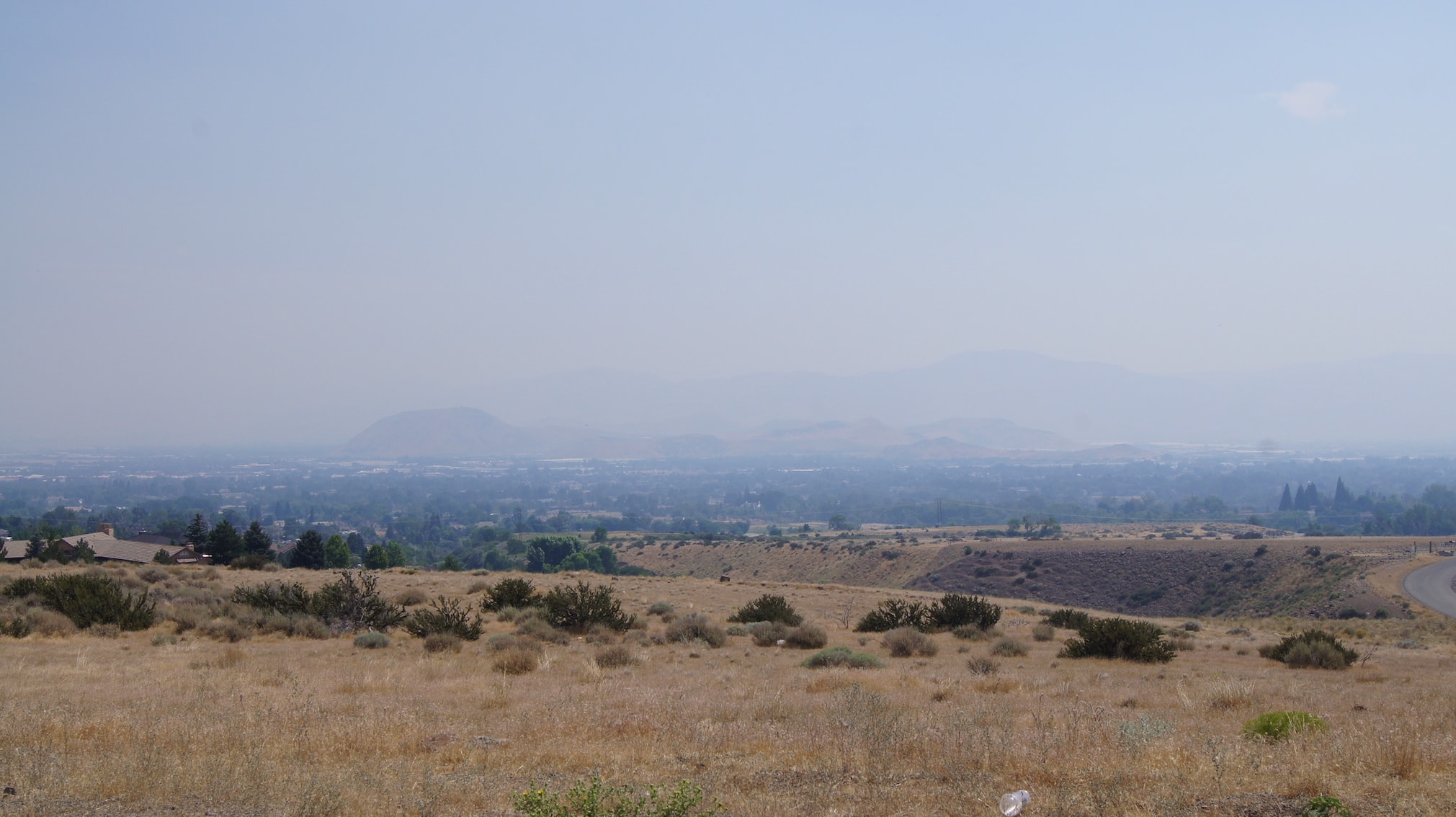 A view of the plains with foggy mountains in the background