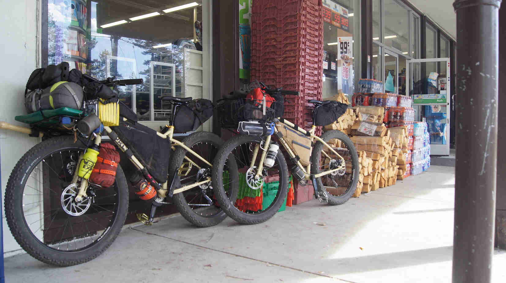 Surly fat bikes parked against a wall in front of a grocery store